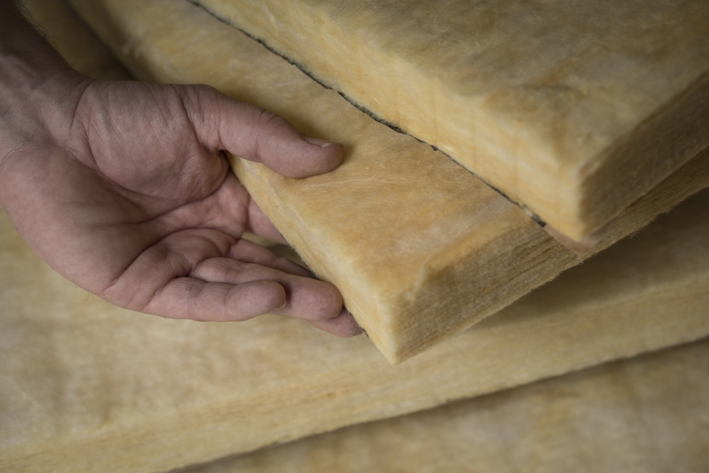 hand touching sheets of fiberglass
