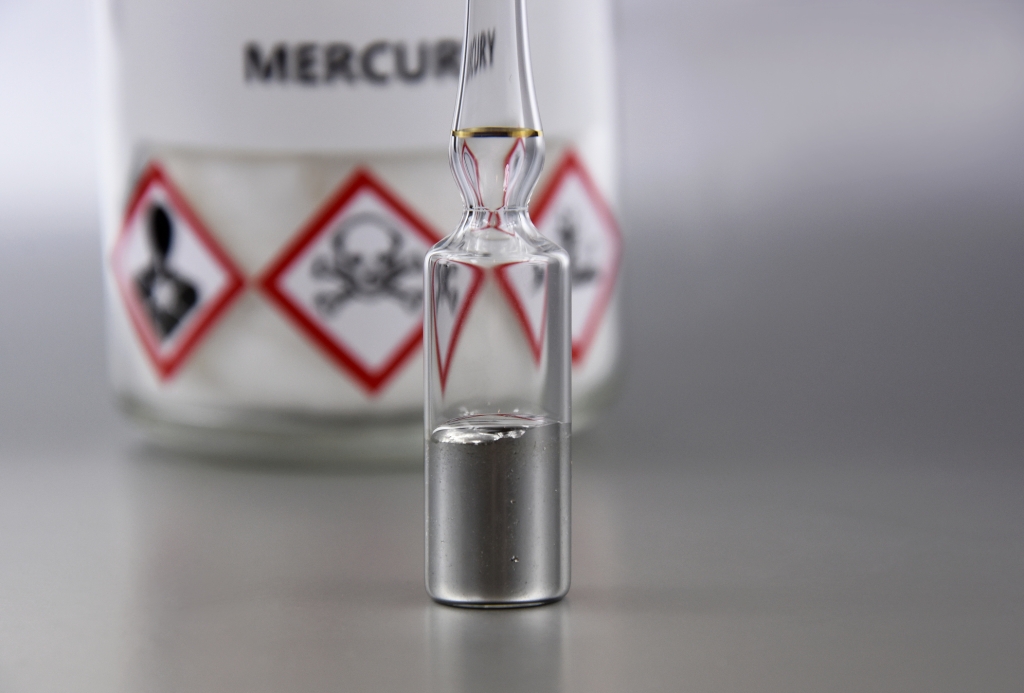 Mercury in a sealed ampoule. Laboratory equipment on a silver background.