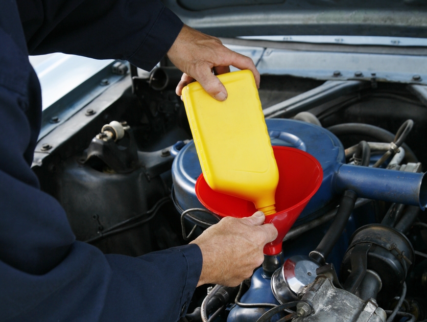 motor oil bottle being poured into a car