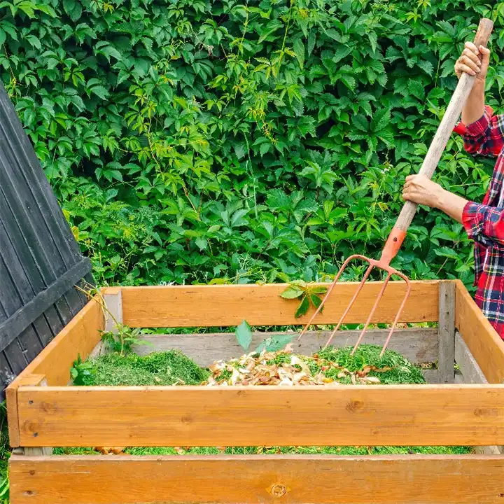 Person working on a pile of compost